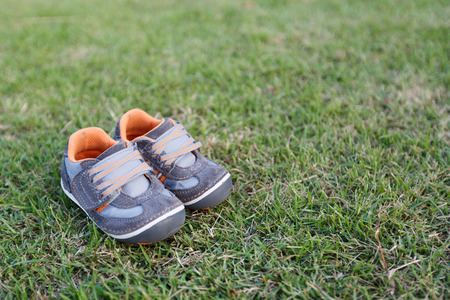 Baby shoes is on the green grass.の写真素材