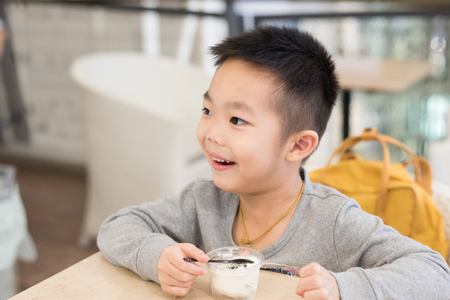 Happy young boy eating an ice creamの写真素材