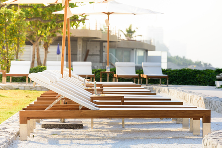 Sun beds and umbrellas at the poolside.の写真素材