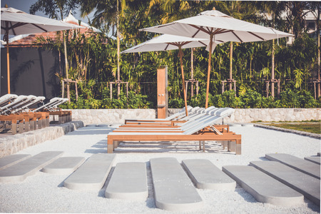 Sun beds and umbrellas at the poolside.の写真素材