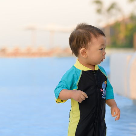 cute baby boy wearing swimsuit in the swimming poolの写真素材