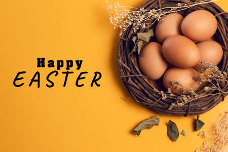 easter eggs food with vine wood and fabric and dried flower on yellow background in top view
