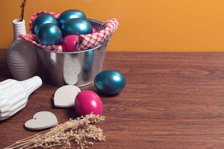 close up food vintage colorful easter eggs with wood vine and flower on yellow background