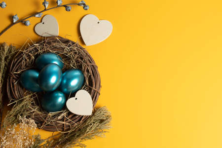 colorful vintage blue easter eggs festival seasoning with yellow background with heart wood decoration propの写真素材