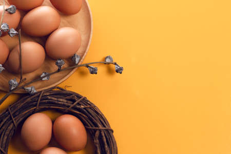 easter egg food with wood circle and dried flower on yellow background top view of vintage styleの写真素材