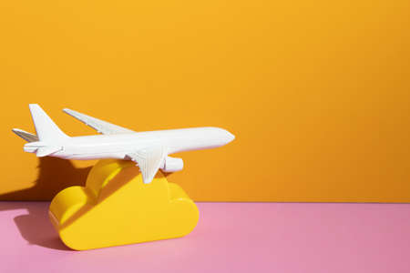 airplane toy model with cloud on yellow background in transportation business for travel tourist international concept, summer season holiday vacation, logistic import exportの写真素材