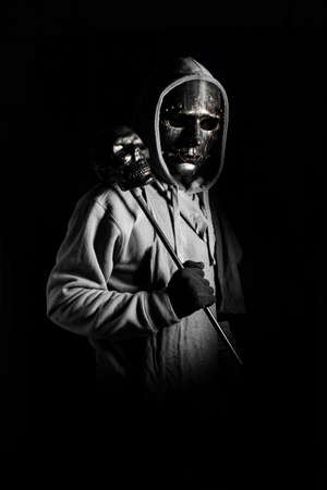 man in halloween costume of ghost evil with black metal mask and wear hooded in darkness conceptの写真素材