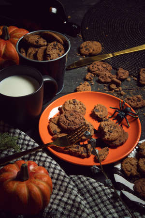 sweet biscuit cookies dessert and milk with halloween holiday dinner prop decoration with wood table backgroundの写真素材