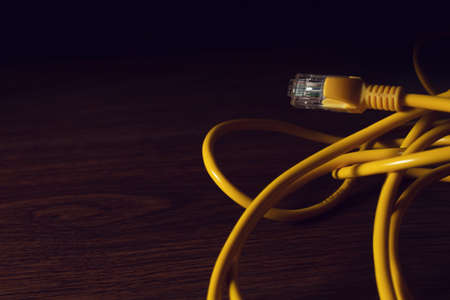 digital internet network server online lan yellow wire with security business and technology concept on black background with wood office deskの写真素材