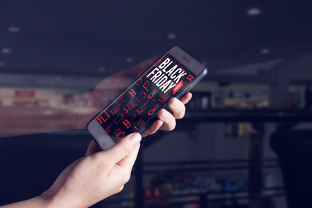 girl hand holding network online smartphone device application for buy product in black friday shopping discount sale season event weekend in supermarket store conceptの写真素材