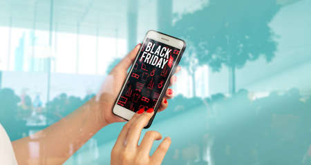 girl hand holding network online smartphone device application for buy product in black friday shopping discount sale season event weekend in supermarket store conceptの写真素材