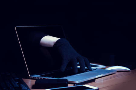 hacker hand in terrorist with virus computer attack robbery to unlock server network system online in data internet, security hacking system conceptの写真素材