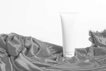 cosmetic mockup cream in bottle pakage with beauty spa treatment with textile fabric on white backgroundの写真素材