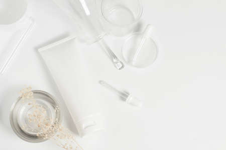 top view beauty spa medical skincare concept, cosmetic lotion bottle packaging on white decor background with science doctor laboratory test glassの写真素材