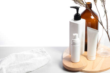 set collection of spa treatment beauty cosmetic with herb and glassware with towel on white...