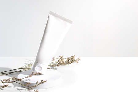 white beauty cream cosmetic tube packaging with cassia flower in sun morningの写真素材