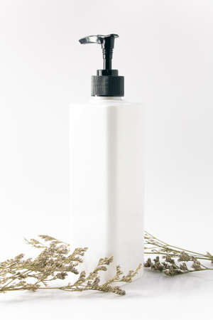 white cream cosmetic packaging bottle mockup with flower flora dried on white background