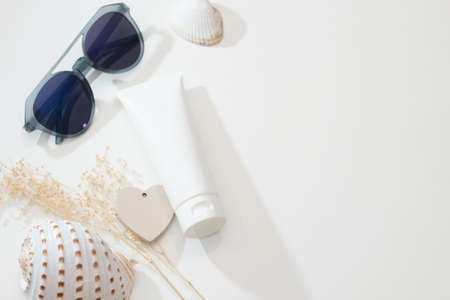 top view with fashio sunglasses summer concept of spa sea beach beauty cosmetic body lotion cream aroma perfume sunscreen spf mockup package product with shell and flower on tableの写真素材