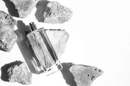 top view of perfume bottle glass luxury packaging with stone rock concrete grunge on white background, aroma smell of cosmetic beauty containerの写真素材