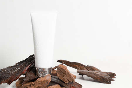 white beauty fashion cosmetic makeup spa cream lotion cleanser facial foam container package tube product with herbal tree old wood texture bark with wet waterdrop fresh, isolated backgroundの写真素材