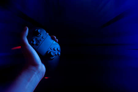 gamer boy with hand holding the joystick controller electronic for playing game with online network...