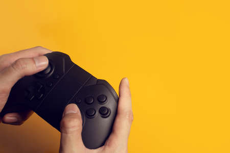 gamer boy with hand holding the joystick controller electronic for playing game with online network...