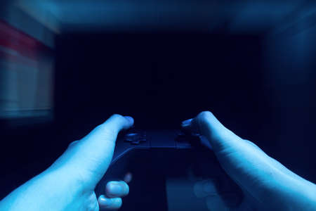 gamer boy with hand holding the joystick controller electronic for playing game with online network...