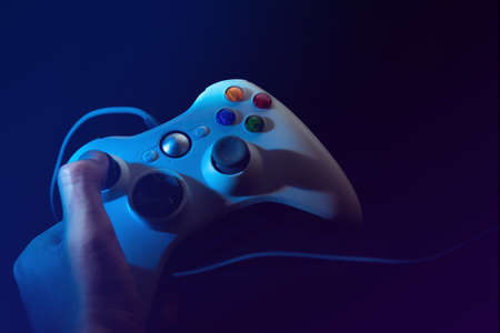 man hand holding the joystick controller electronic for playing game with online network connection in esport tournament challenge concept, technology deviceのeditorial素材