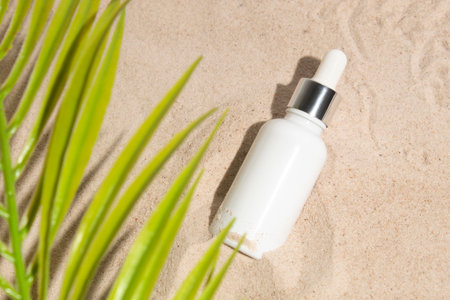 mockup of beauty fashion cosmetic dropper bottle lotion product on summer sea sand beach with leaf palm coconut treeの写真素材
