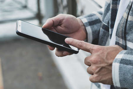 teen boy using smartphone device for online network technology internet;  man use mobile in public...