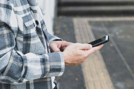 teen boy using smartphone device for online network technology internet;  man use mobile in public...