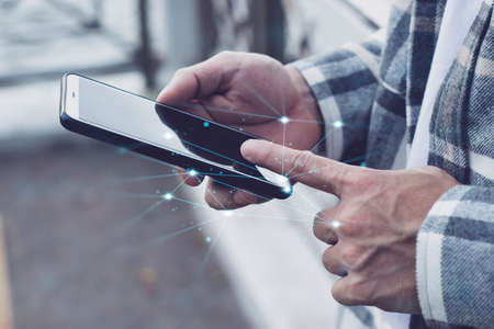 teen boy using smartphone device for online network technology internet;  man use mobile in public parkの写真素材