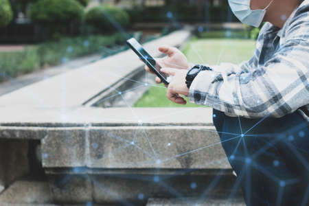 teen boy using smartphone device for online network technology internet;  man use mobile in public parkの写真素材