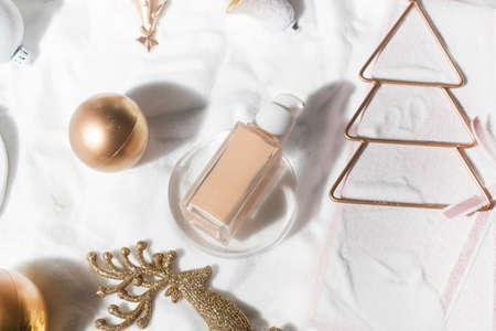 white snow background with lifestyle, cosmetic makeup bottle lotion cream product mockup with beauty fashion skincare for merry christmas festival giftの写真素材