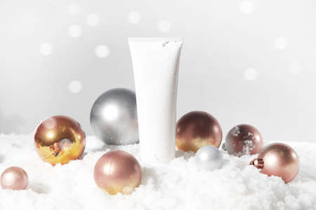 white snow background with lifestyle, cosmetic makeup bottle lotion cream product mockup with beauty fashion skincare for merry christmas festival giftの写真素材