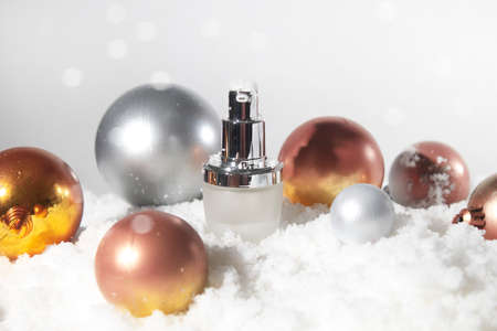 white snow background with lifestyle, cosmetic makeup bottle lotion cream product mockup with beauty fashion skincare for merry christmas festival giftの写真素材
