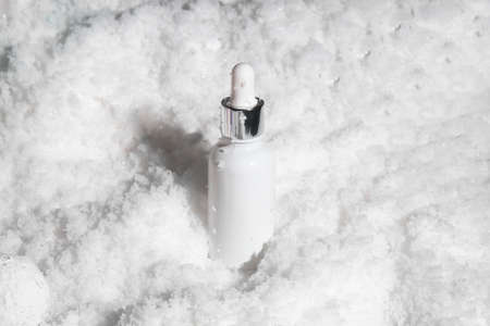white snow background with lifestyle, cosmetic makeup bottle lotion cream product mockup with beauty fashion skincare for merry christmas festival giftの写真素材
