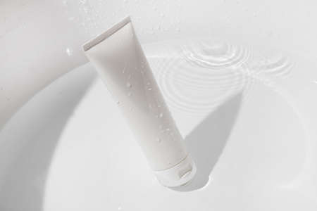 mockup of medical skin care bottle cosmetic tube of beauty makeup facial, treatment cleanser face foam, beauty healthcare branding packaging in water splashの写真素材