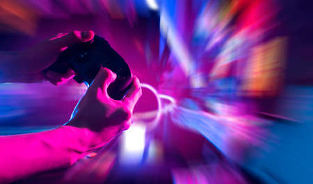 gamer playing the online game with joystick controller in neon glow dark cyberpunk room, gaming and...