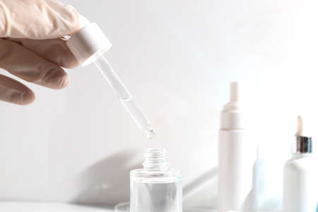 scientist with hand and mockup tube bottle for skin care cosmetic , product branding, cream lotion treatment, laboratory room testing experimentalの写真素材