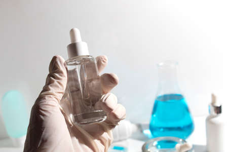 scientist with hand and mockup tube bottle for skin care cosmetic , product branding, cream lotion treatment, laboratory room testing experimentalの写真素材