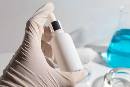 scientist with hand and mockup tube bottle for skin care cosmetic , product branding, cream lotion treatment, laboratory room testing experimentalの写真素材