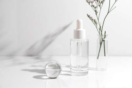 mockup tube bottle for skin care cosmetic, product branding, serum dropper cream lotion treatment with natural flowerの写真素材