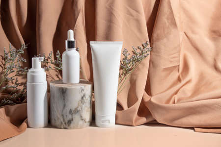 mockup tube bottle for skin care cosmetic, product branding, serum dropper cream lotion treatment with natural flowerの写真素材