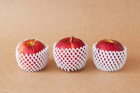 group of red apples with protective packaging on paper backgroundsの写真素材