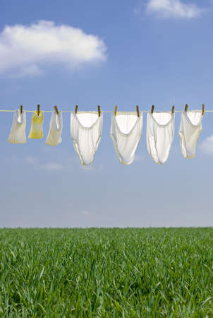 Clothes drying in the summer breeze on clear blue sky with soft cloudsの写真素材