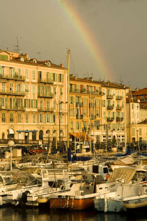 Port of Nice after the storm with rainbow and dark cloudsの写真素材