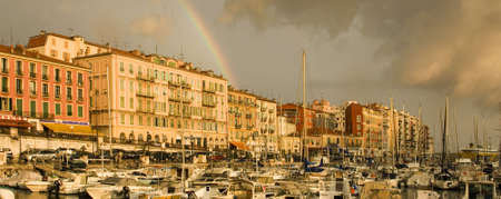 Port of Nice after the storm with rainbow and dark cloudsの写真素材