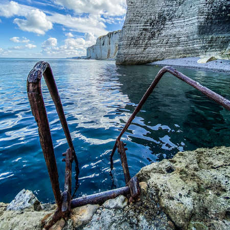 Ladder going down in the sea with on the background Limestone cliffs at Etretat, French Coastの写真素材