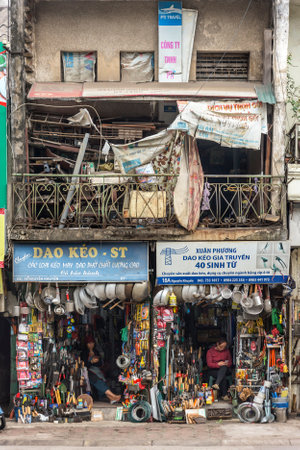 Hanoi, Vietnam, December 30, 2019 - 
Saleswoman looking at her cell phone while waiting for a customer in a tiny specialty store on the streets of Hanoiのeditorial素材